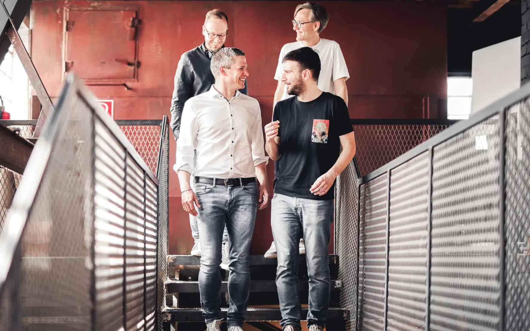 B2C & B2B E-Commerce mit valantic Austria Vier valantic Austria Mitarbeiter besprechen ein Projekt und gehen eine Treppe runter.