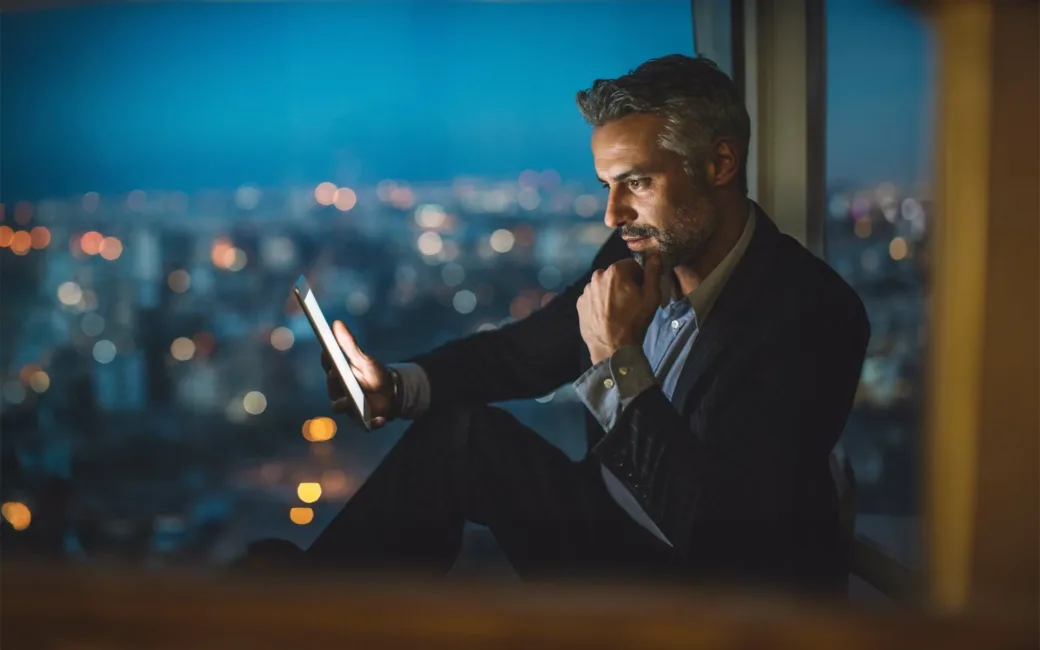 businessman-looking-at-digital-tablet-at-night-624978806 Business partnership coworkers using a tablet to analysis graph company financial budget report and cost work progress and planning for future in office room.