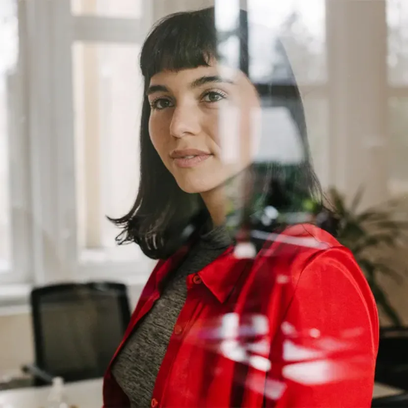 Businesswoman Wearing Red Shirt Standing Behind Glass Window