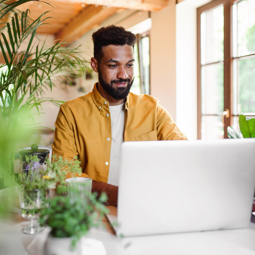 man-with-laptop-and-coffee-working-indoors-home-office-1334702614 A young man with laptop and coffee working indoors, home office concept.