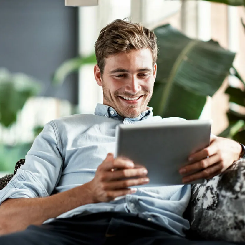 young-man-using-tablet-on-couch-640309910 Shot of a happy young man using his tablet while relaxing on the couch at home