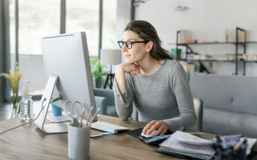 Mulher a trabalhar a partir de casa Profissional do género feminino sentada numa secretária a trabalhar em regime de teletrabalho