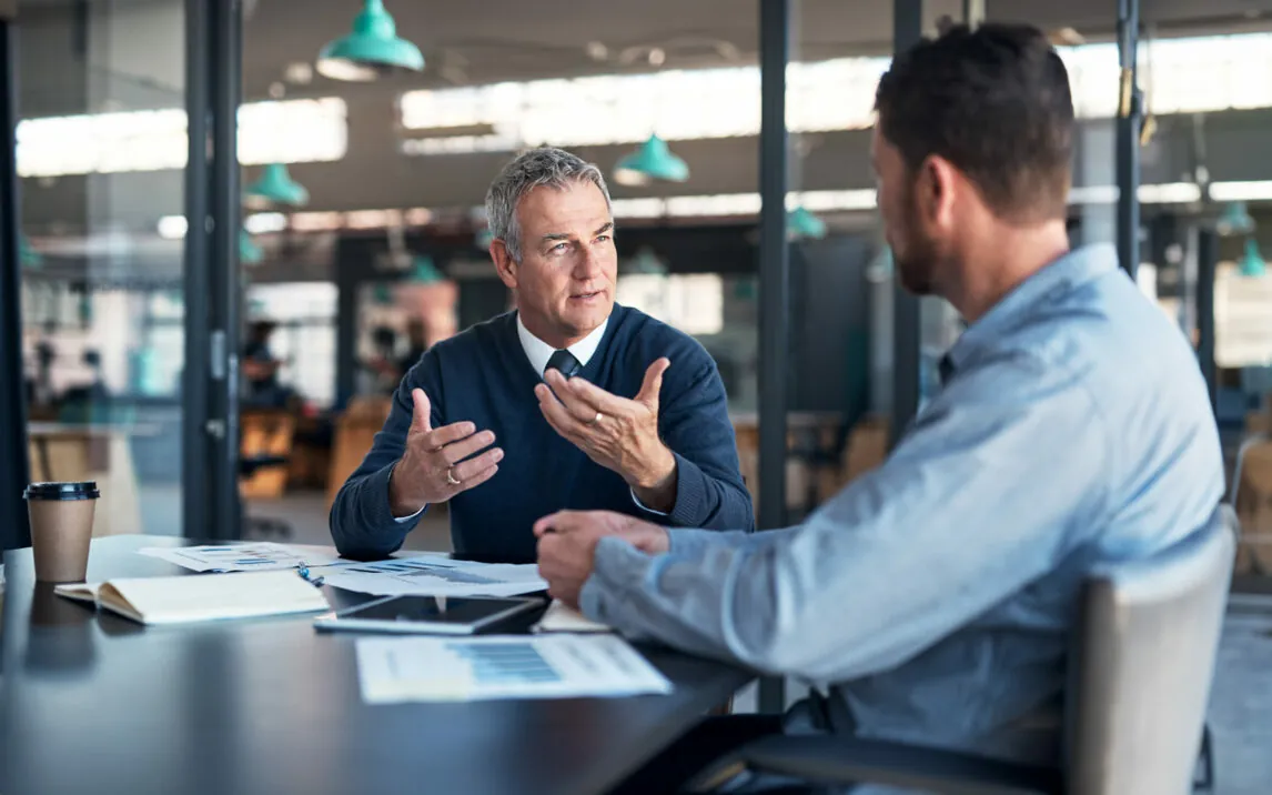 explaining-his-vision-to-a-colleague-1185858776 Shot of a mature businessman having a discussion with a colleague in an office