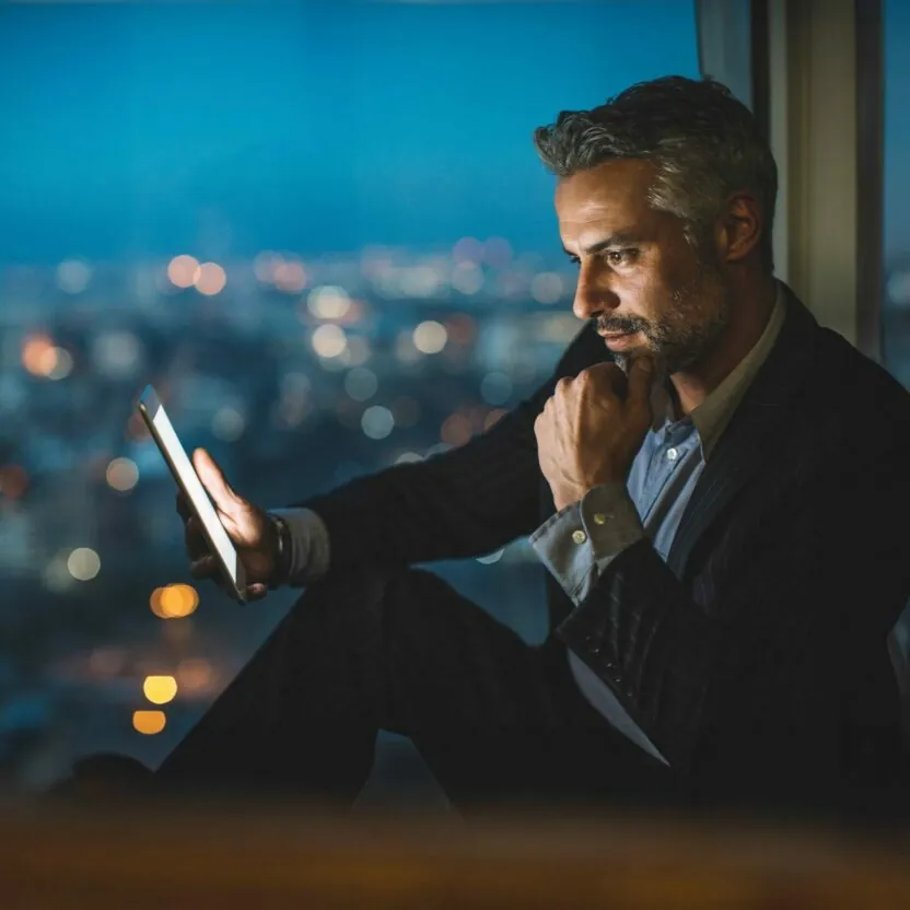 businessman-looking-at-digital-tablet-at-night-624978806 Business partnership coworkers using a tablet to analysis graph company financial budget report and cost work progress and planning for future in office room.