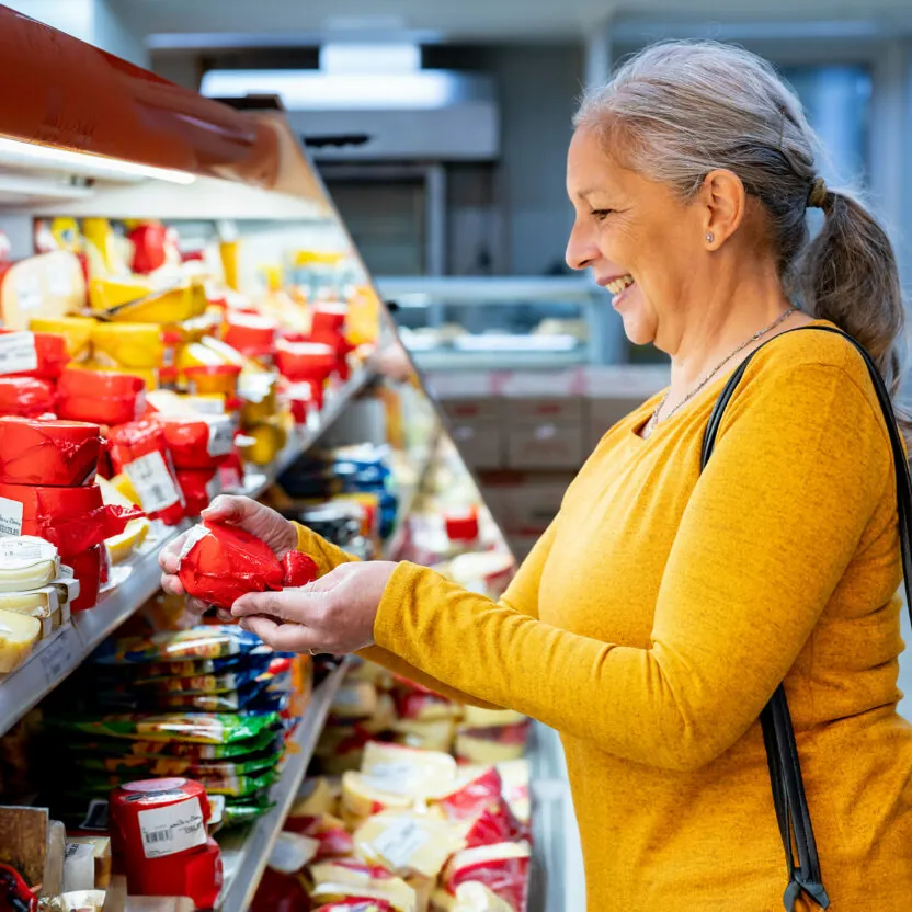 elderly-woman-buying-cheese-in-supermarket-1497211596 Elderly woman buying cheese in supermarket.