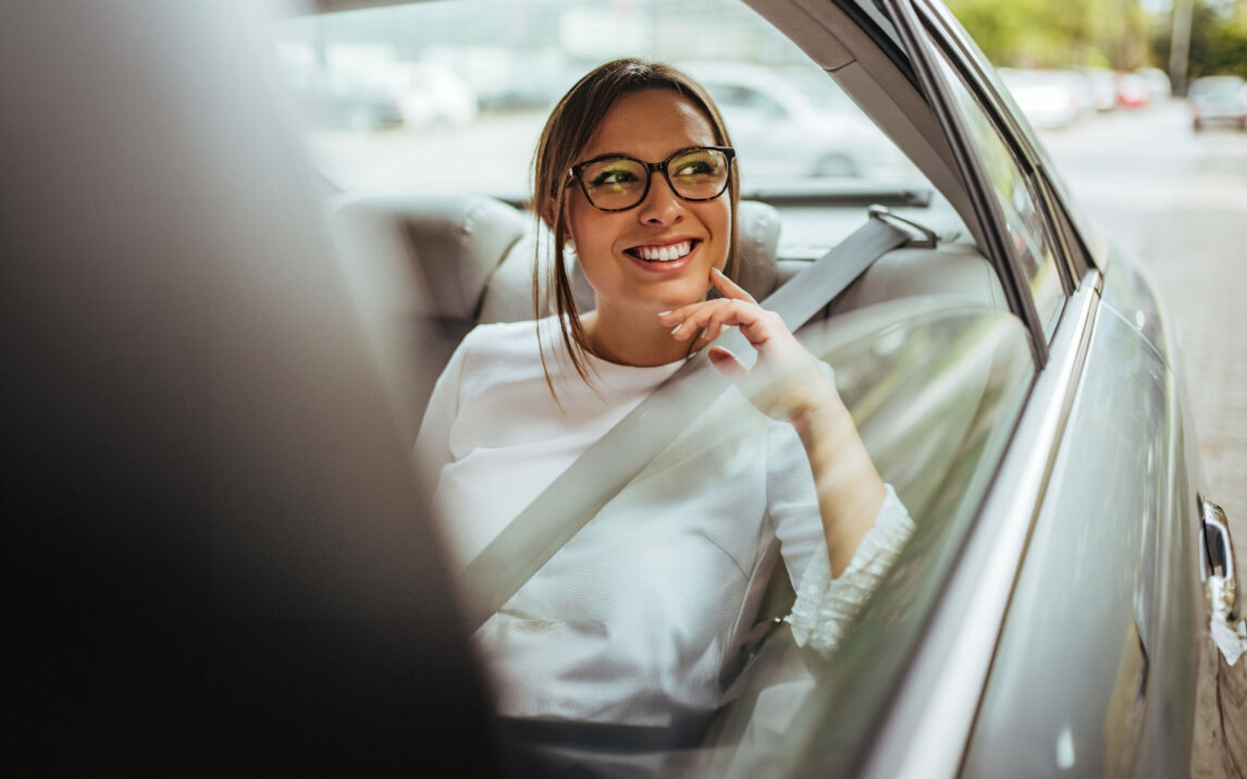 woman-in-car-looking-out-of-window-1177417290 Portrait of a woman in back seat of car looking out of window