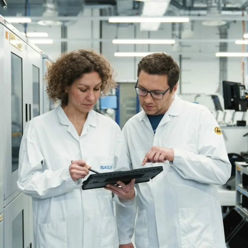 Basler AG employees looking at tablet Basler AG employees looking at tablet
