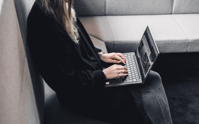 Content-Marketing-Redakteurin, die am Laptop arbeitet.