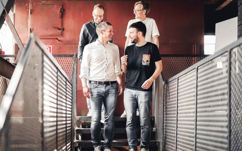 B2C & B2B E-Commerce mit valantic Austria Vier valantic Austria Mitarbeiter besprechen ein Projekt und gehen eine Treppe runter.