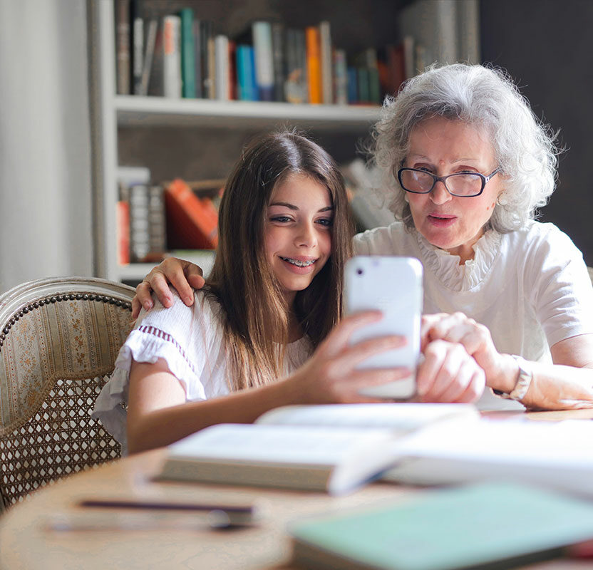 Enkelin und Grossmutter am Smartphone Enkelin und Großmutter nutzen auf dem Smartphone eine EAA-konforme Plattform oder einen barrierefreien Onlineshop