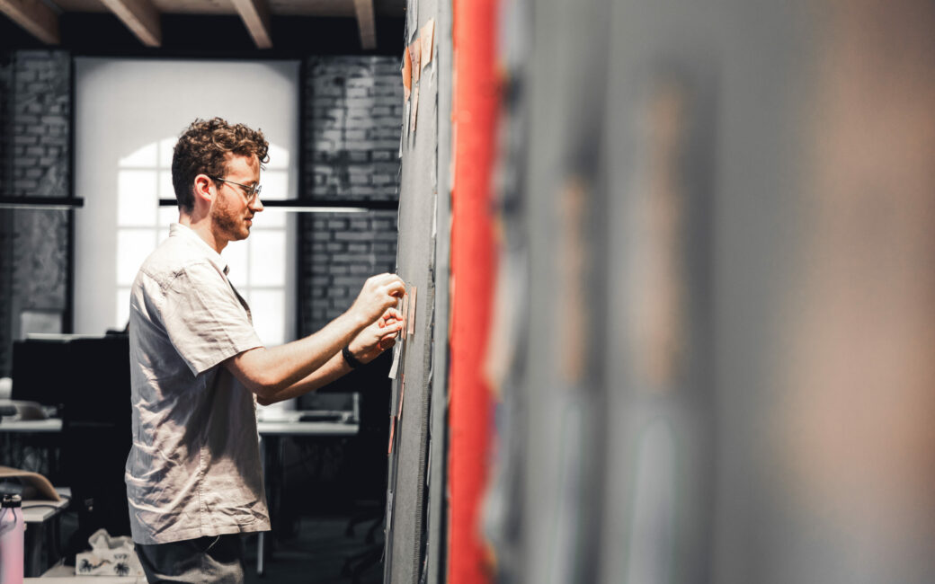 Photo of a young valantic Austria employee taking notes on a glass wall during an SEO workshop.