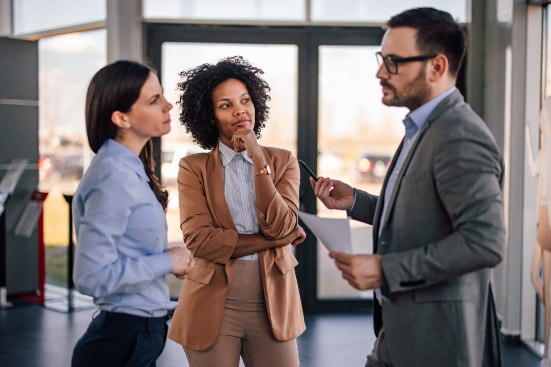 Focused businesspeople, standing together in the company hall. Focused businesspeople, standing together in the company hall.