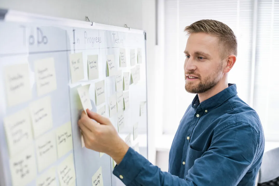 valantic-cx-projekt-management Picture of man on whiteboard with post-its