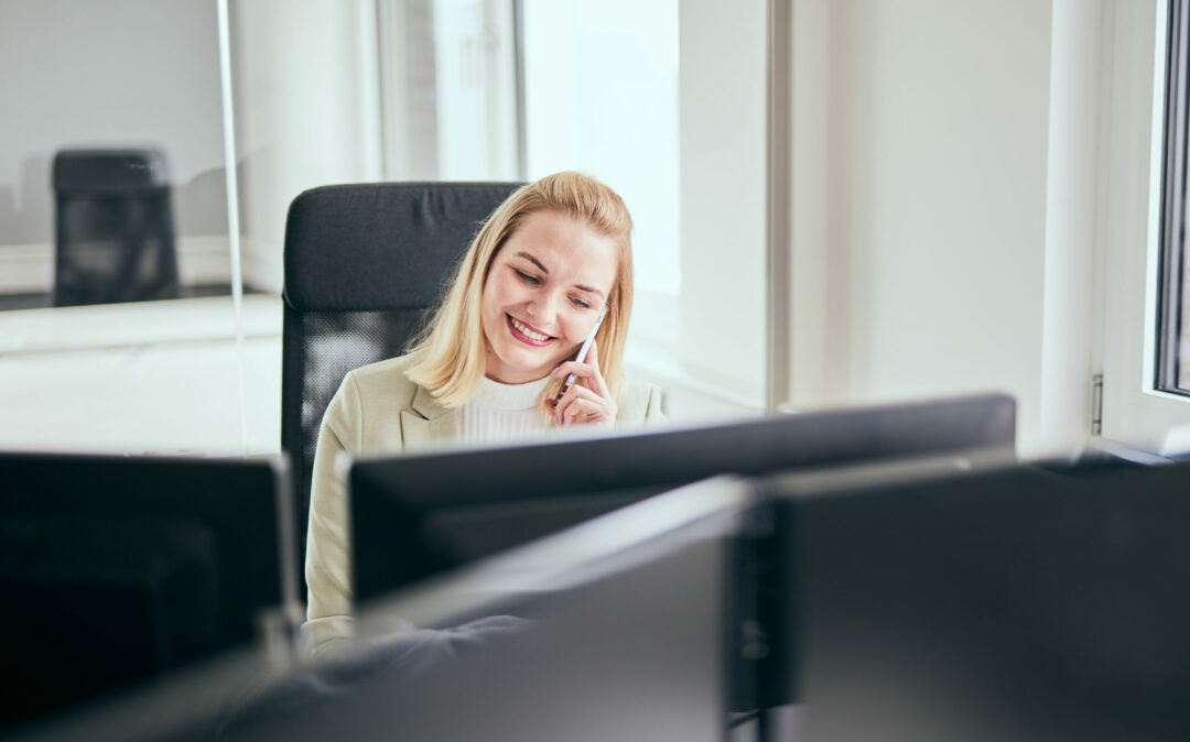 Valantic-CX-Langenfeld-14609 Photo of a valantic CX employee talking to a customer on the phone at her desk.