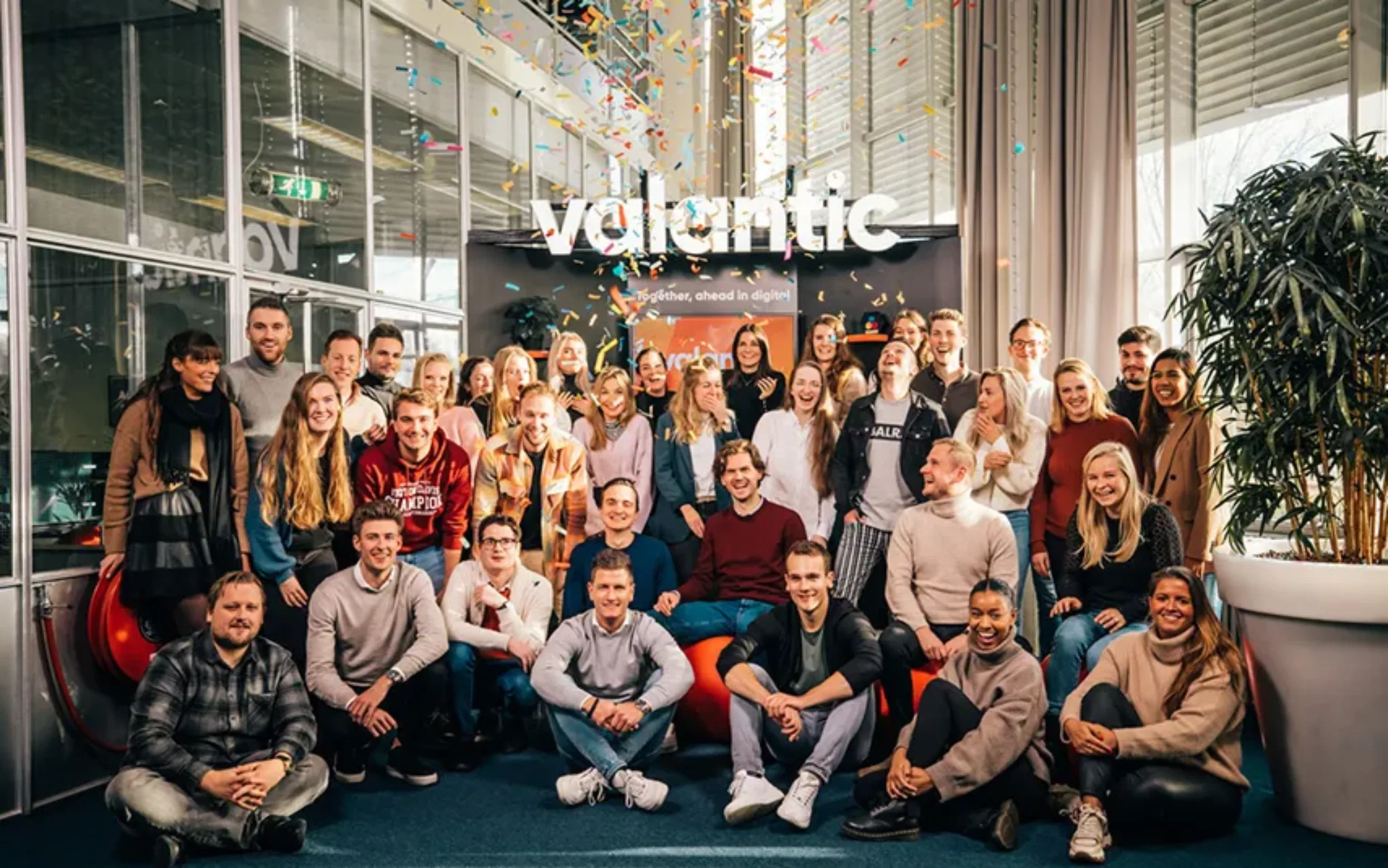 valantic NL Team vor dem Büroeingang mit Konfetti valantic NL Team vor dem Büroeingang mit Konfetti
