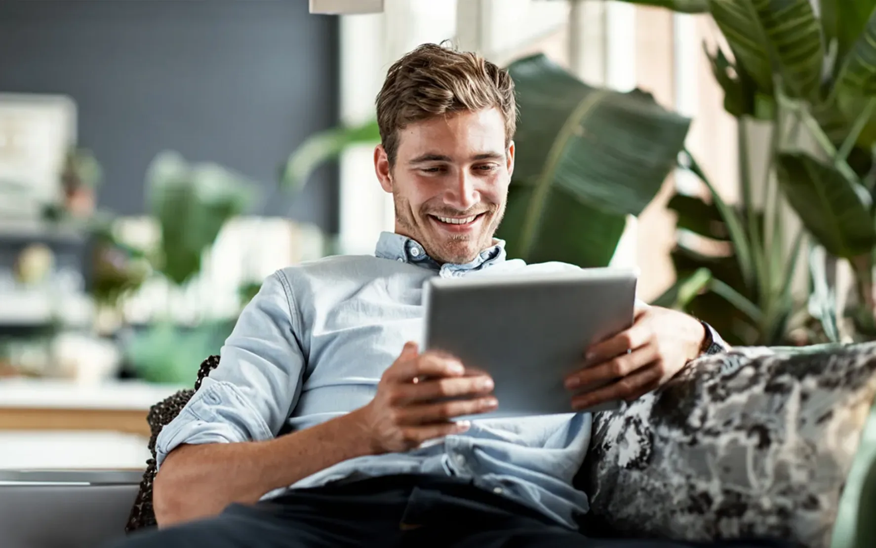 young-man-using-tablet-on-couch-640309910 Shot of a happy young man using his tablet while relaxing on the couch at home